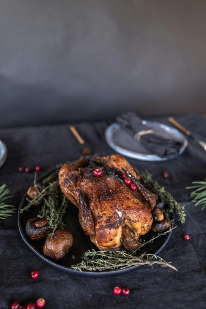 Delicious roasted chicken garnished with fresh herbs and cranberries, perfect for holiday feasts.
